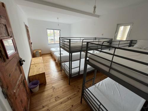 a room with four bunk beds and a wooden floor at Residencial Avenida Hostel in Tomar
