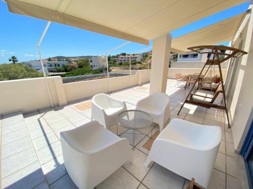 a balcony with white chairs and a ladder at The Beachhouse Apartments in Vaia