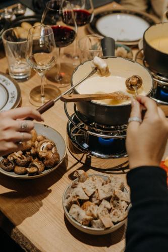 a table with plates of food and a pot of food at M de Megève in Megève