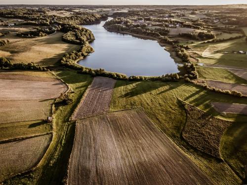 an aerial view of a field and a river at Domki na Kaszubach - Chabry i Rumianki - Roztoka, Przywidz - Basen Sauna Jacuzzi KASZUBY in Roztoka