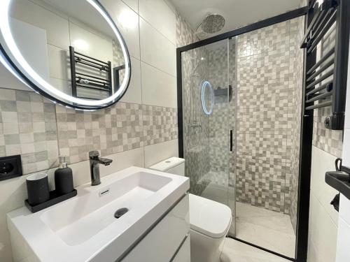 y baño con lavabo blanco y espejo. en HomeStay Lopez Pando, en Madrid