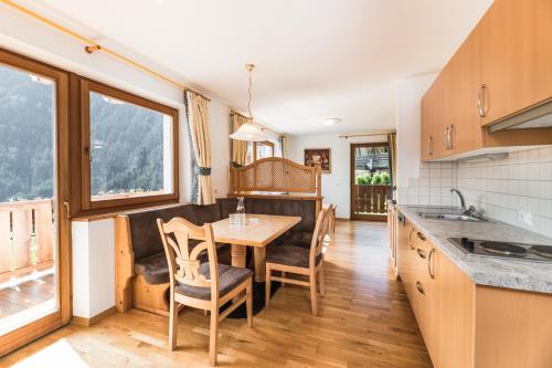 a kitchen and dining room with a table and chairs at Residence Rumanon in Ortisei