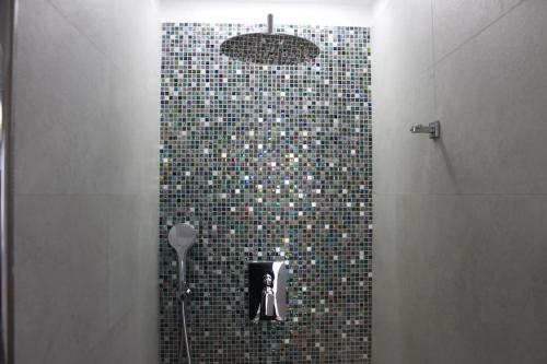 a bathroom with a shower with a tile wall at L'angolo di Greta in Rome