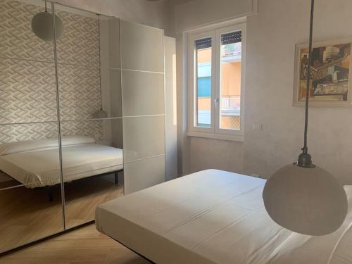 um quarto branco com uma cama e uma janela em L'angolo di Greta em Roma