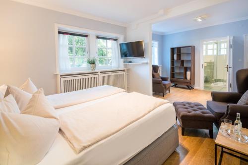 シュネーヴァーディンゲンにあるHotel Schäferhofのベッドルーム(大型ベッド1台付)、リビングルームが備わります。