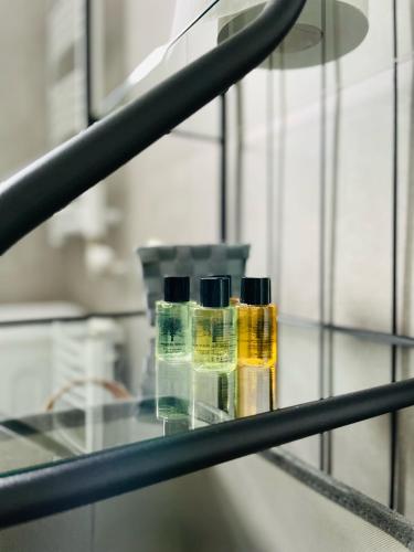 two bottles of essential oils sitting on a glass shelf at Pistacjowy - Apartamenty Smart Projekt in Tarnów