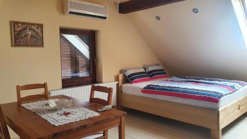 1 dormitorio con cama, mesa y ventana en Hiška pri Tisi, en Ptujska Gora