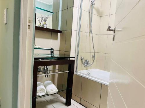 a bathroom with a shower and a sink and a tub at Cozy Self Catering Apartment with Golf Course Views, Jackal Creek Golf Estate in Roodepoort
