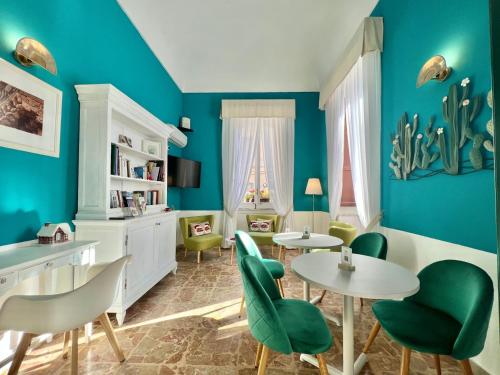 a living room with blue walls and tables and chairs at Hotel Posta in Syracuse