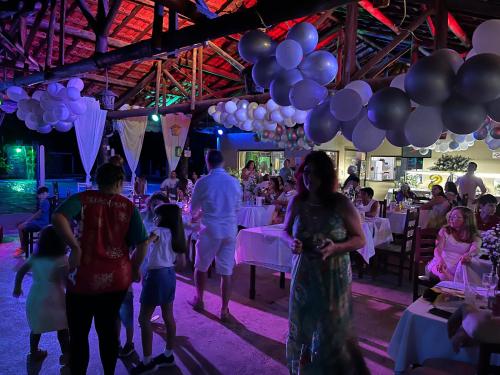 un grupo de personas caminando alrededor de una fiesta con globos en Ananda pousada chalé en São Pedro