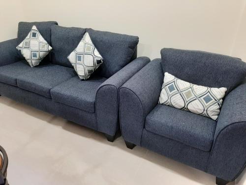 a blue couch with two pillows in a living room at PESHERES INN & SPA in Bon Accord
