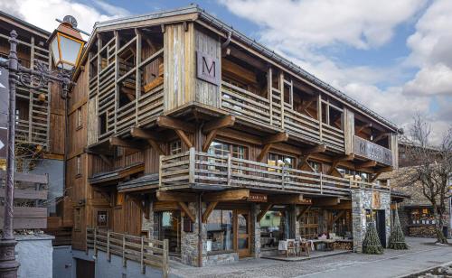 a large wooden building on the side of a street at M de Megève in Megève