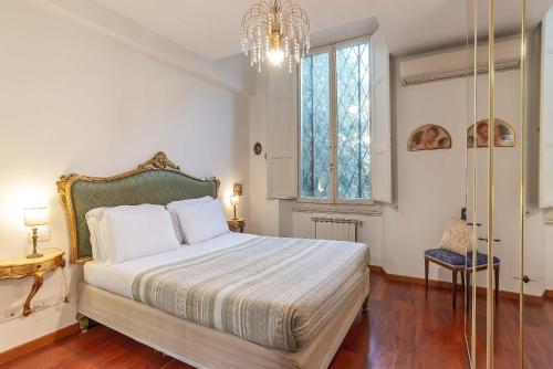 Un dormitorio con una cama grande y una lámpara de araña. en MDR Antinori Apartments, en Florencia