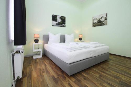 ein Schlafzimmer mit einem Bett, zwei Lampen und einem TV in der Unterkunft Holiday flat Askani Ballenstedt - DMG03102h-EYC in Ballenstedt