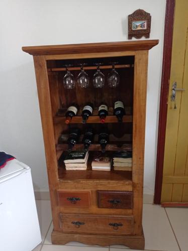 a cabinet filled with wine bottles and wine glasses at Pouso Casa da Vovó in Tiradentes