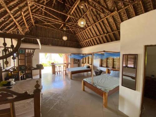 a bedroom with two beds and a living room at Baobab Beach Villa, Ushongo Beach, Pangani in Ushongo Mabaoni