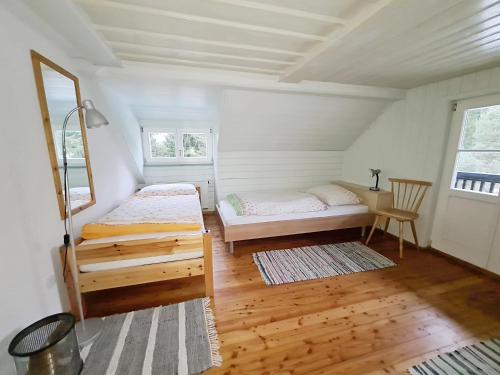 1 dormitorio con 2 camas en una habitación con suelo de madera en Haus Völlegg, en Völlegg