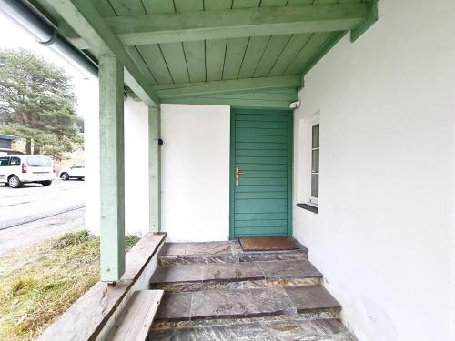 a porch with a green door on a house at Haus Völlegg in Völlegg