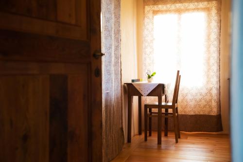 a table and a chair in a room with a window at Villa D'Or in Mel