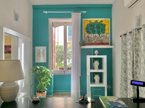 a living room with blue walls and a window at Hotel Posta in Syracuse