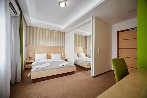 a large bedroom with two beds and a mirror at Laurus Motel Airport Tuzla in Živinice