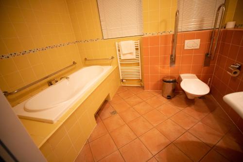 a bathroom with a tub and a toilet at Hotel Sport in Karviná