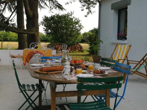 a wooden table with chairs and food on it at Le moulin de La Retardière in Orvault