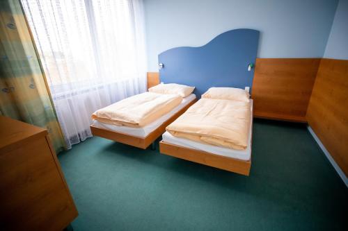 a bedroom with two beds in a room with a window at Hotel Sport in Karviná