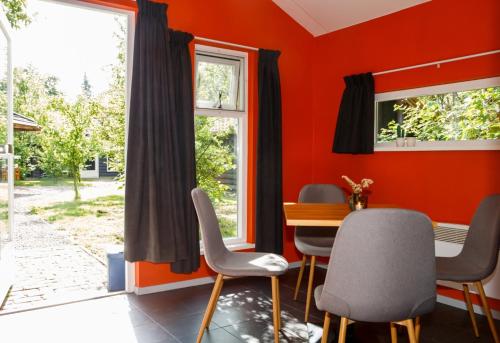 a dining room with red walls and a table and chairs at Het Wachterspunt / Herberg de Vrolijke Jager in Oirschot