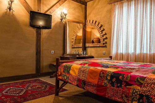 a bedroom with a bed and a tv and a mirror at Khan Lankaran Hotel in Lankaran