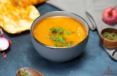 a bowl of soup sitting on a table with bread at Khan Lankaran Hotel in Lankaran