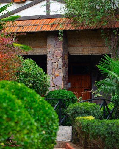 a stone building with a door and some bushes at Khan Lankaran Hotel in Lankaran