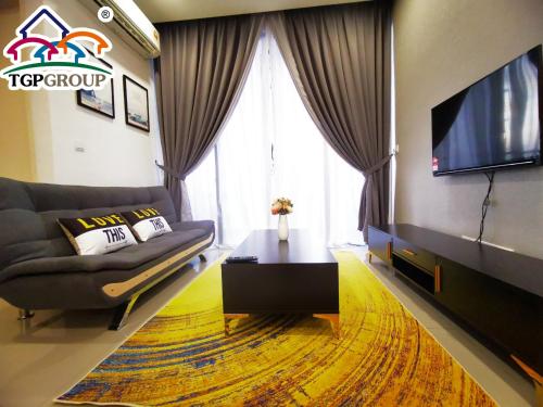 a living room with a couch and a flat screen tv at D'Pristine Design Apartment by TGP in Nusajaya