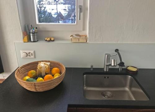 un cesto di frutta seduto accanto a un lavello della cucina di Zentral, Ruhig, Sonnig, Modern a Lenzerheide