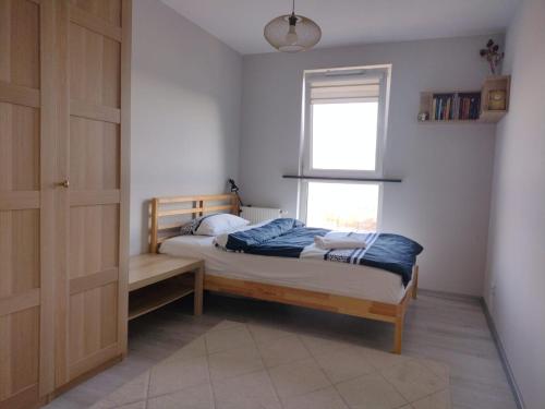 1 dormitorio con cama y ventana en Apartamenty Piastów, en Cracovia