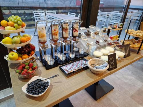 a table with bowls of fruit and other food on it at New Wolf in Bran