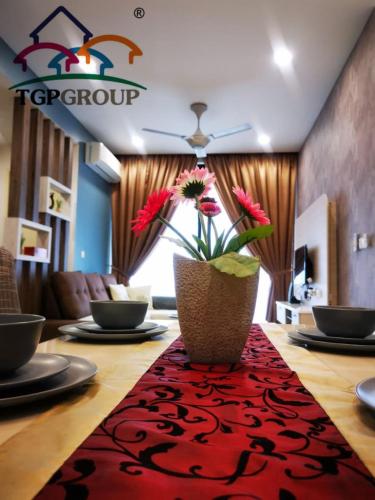 a table with a vase with flowers on a red rug at D'Pristine Design Apartment by TGP in Nusajaya