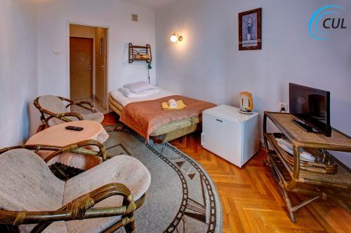 a bedroom with a bed and a tv and a couch at Jawor in Polańczyk