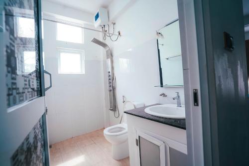 a bathroom with a toilet and a sink at Sun Ray Rest House in Kalkudah