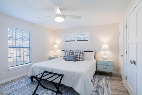 a white bedroom with a bed and two lamps at House in Mobile Newly Renovated! Quiet & Centrally Located! in Mobile