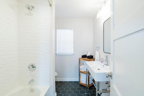 y baño con bañera blanca y lavamanos. en House in Mobile Newly Renovated! Quiet & Centrally Located!, en Mobile