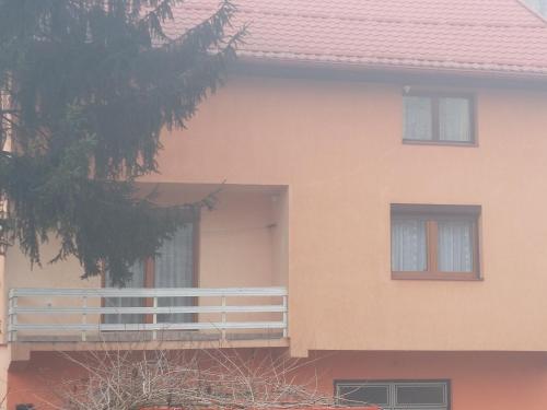 una casa rosa con balcone e albero di Robi kula a Visoko
