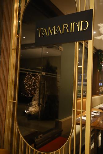 a mirror with the name of a furniture store at The Pristine Hotel in Kānpur