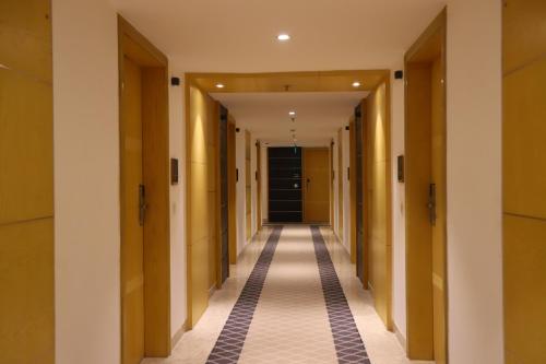 a corridor of hallways in a building with wooden doors at The Pristine Hotel in Kānpur