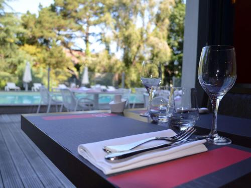 une table avec des verres et de l'argenterie au-dessus d'une table dans l'établissement Mercure Bordeaux Lac, à Bordeaux