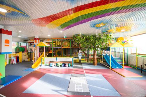 um quarto com um tecto de arco-íris e um parque infantil em Penzion Troja em Lipany