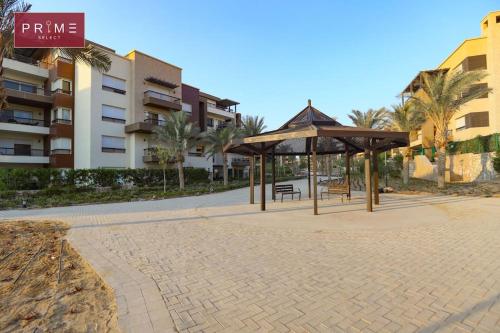 park z ławkami i pawilon przed budynkiem w obiekcie Prime Select New Giza w mieście Giza