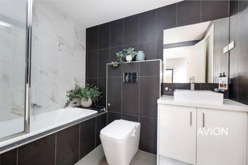een badkamer met een toilet, een bad en een wastafel bij Affordable 2BR Apartment near Melbourne CBD in Maribyrnong