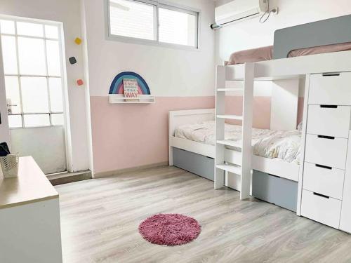 1 dormitorio con litera y alfombra rosa en Hermoso depto centro Rosario en Rosario