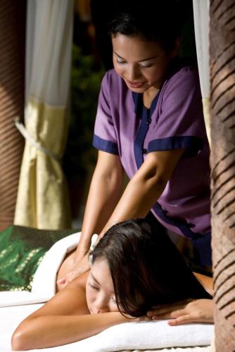 a woman laying on a bed getting a massage at Banyan Tree Tamouda Bay in Fnidek